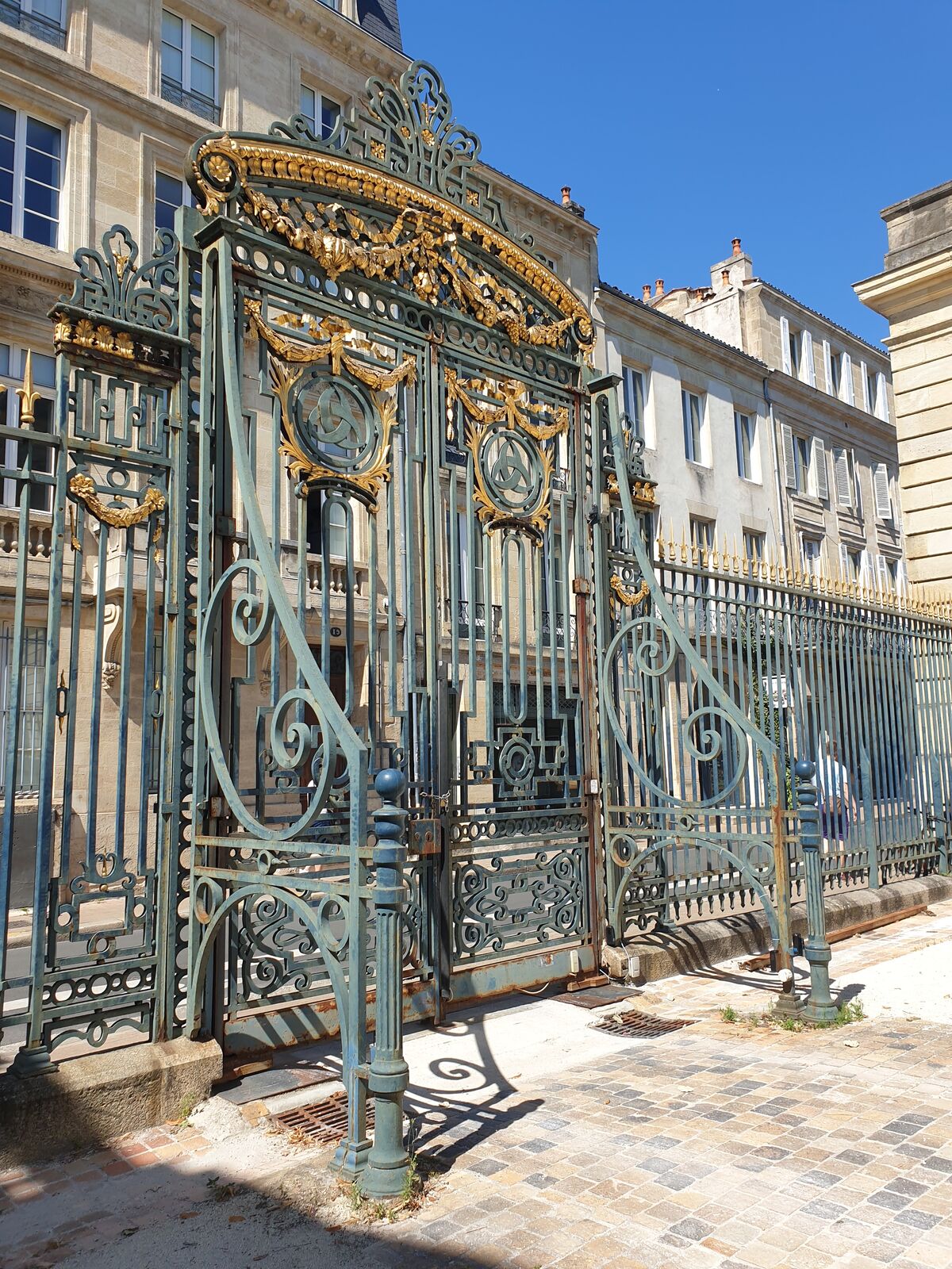 An old cast-iron gate with the three-crescent emblem of Bordeaux